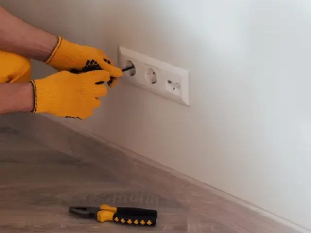 Elektriker installiert eine Steckdose beim Privatkunden