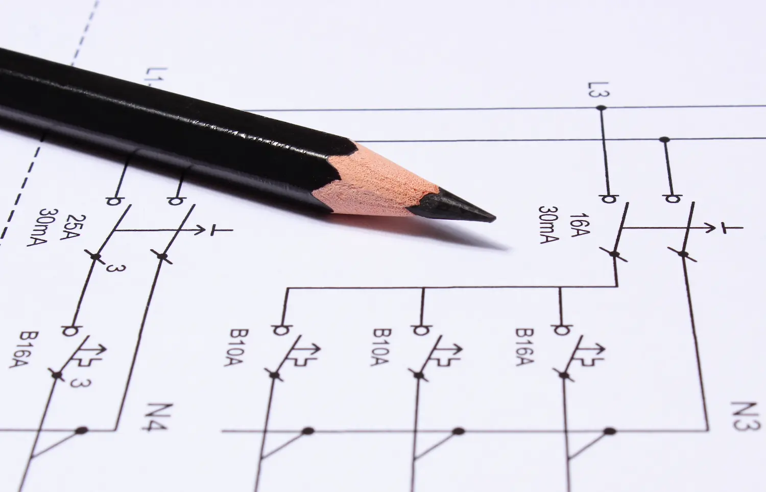 Elektromeister prüft architektonische Pläne am Werkstatttisch